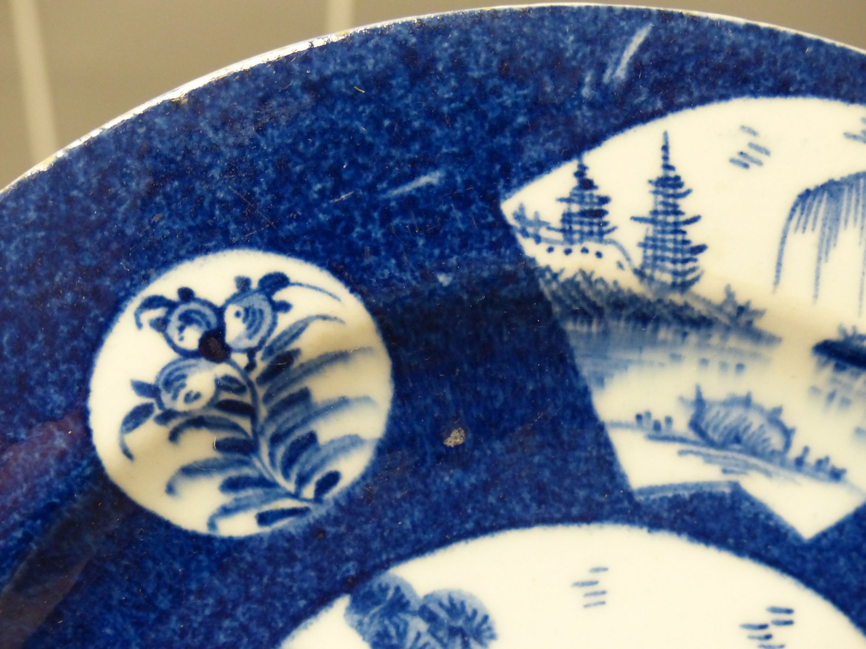 A Bow circular plate painted with landscapes, c.1757, six character mark, 20cm diameter